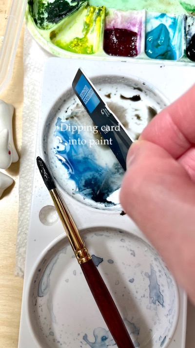 dipping credit card into paint puddle